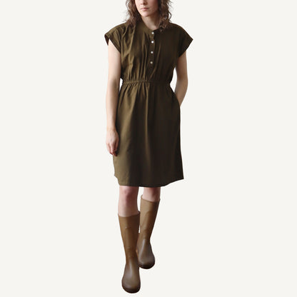 Woman wearing a brown dress and boots on a white background