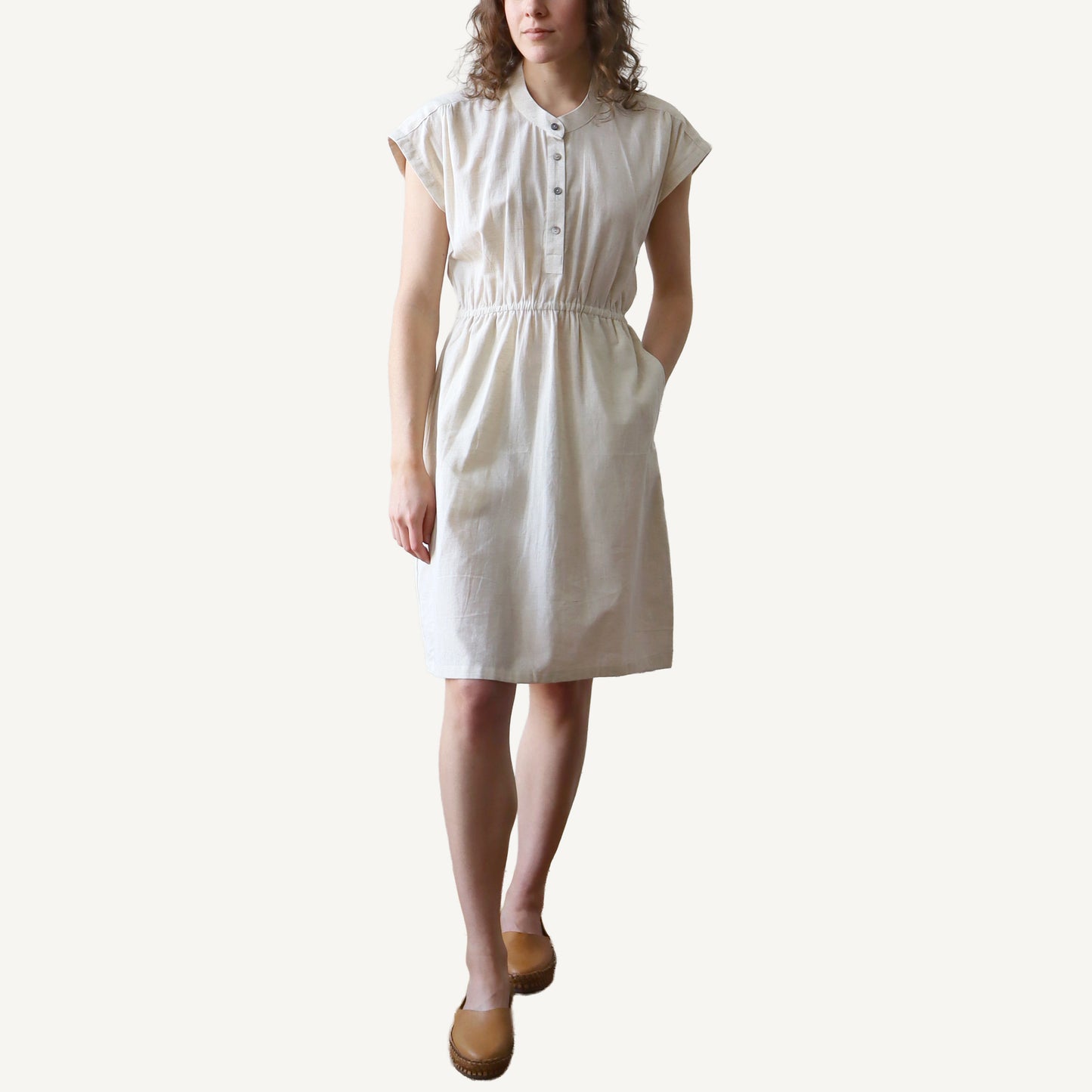 Woman wearing a white dress against a plain background
