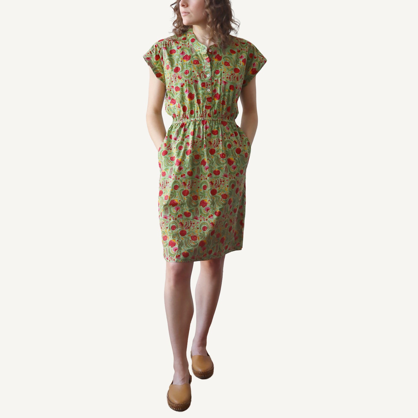 Woman wearing a green floral dress on a white background