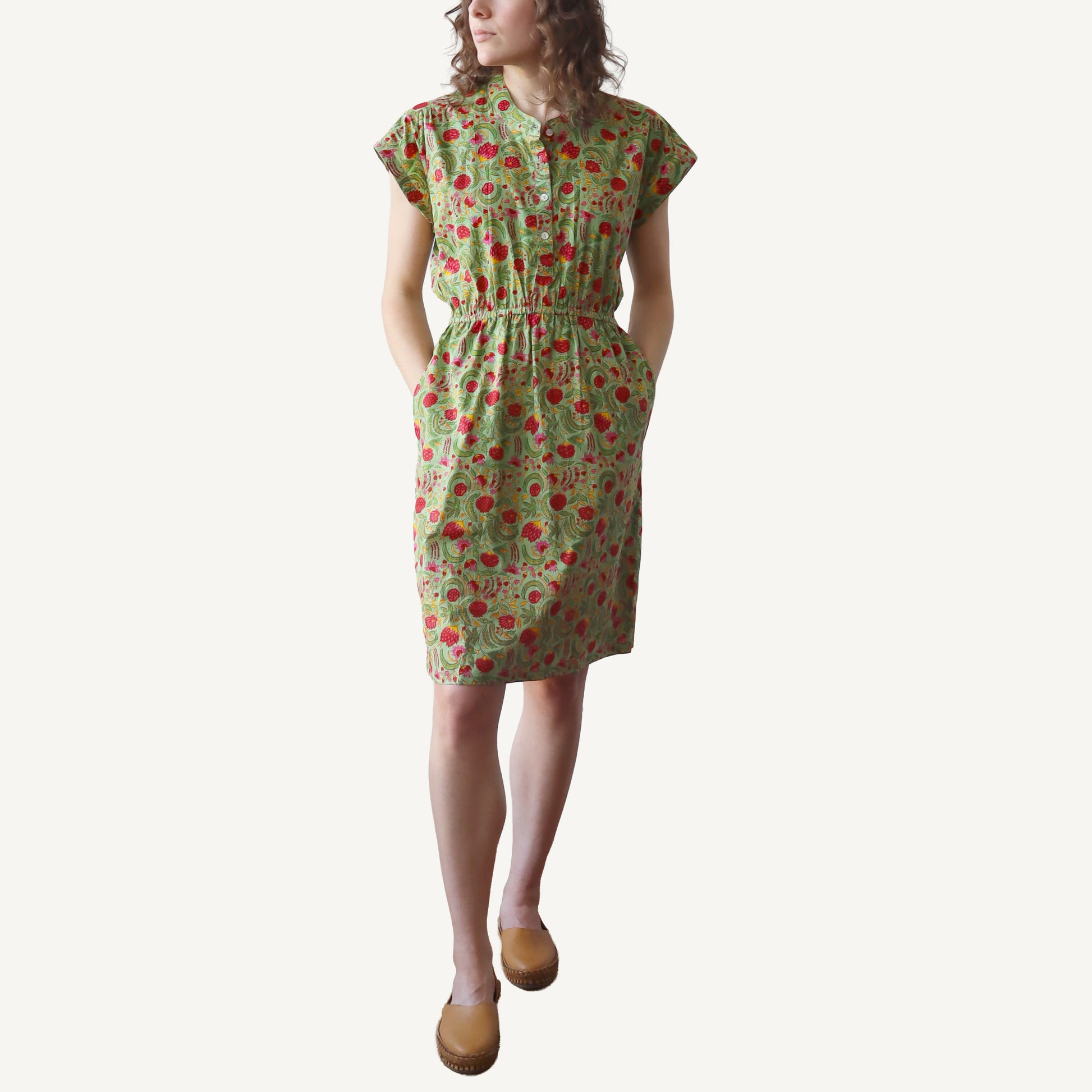 Woman wearing a green floral dress on a white background