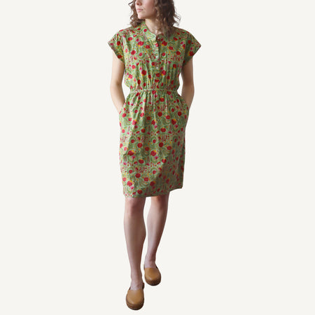 Woman wearing a green floral dress on a white background