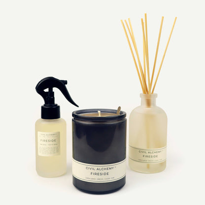 Candle, spray bottle, and diffuser with 'Civil Alchemy Fireside' label on a white background