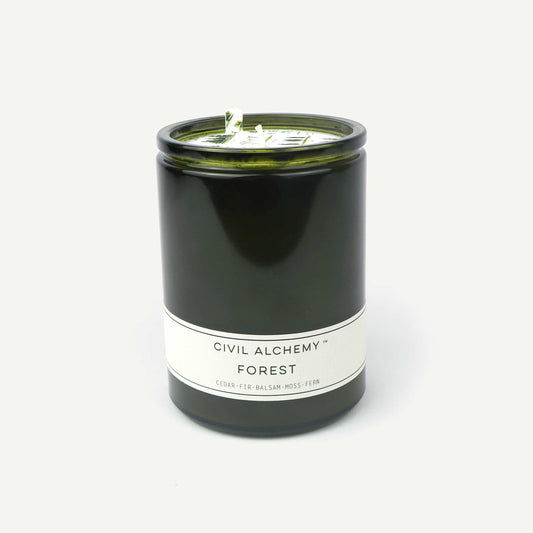 Candle in a green container with a white label on a white background