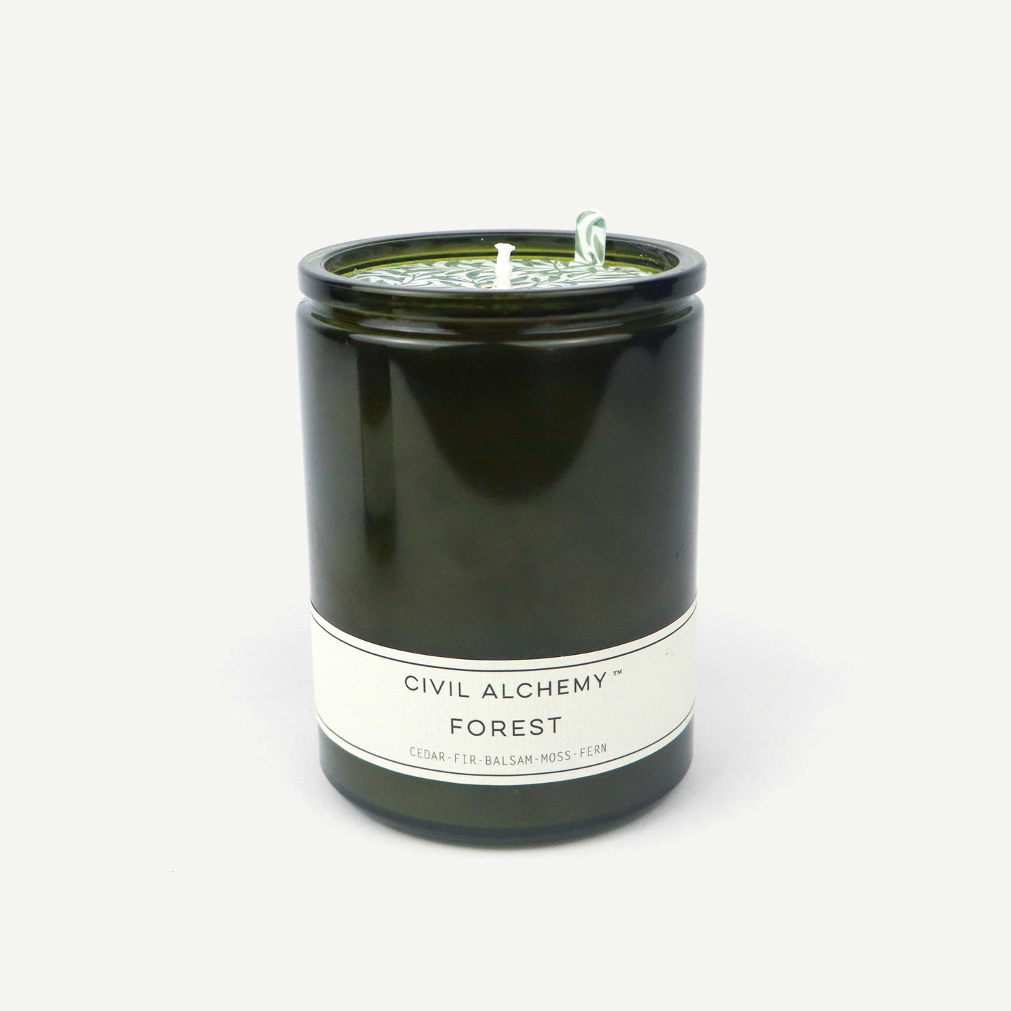 Green candle in a glass jar labeled 'Forest' by Civil Alchemy on a white background