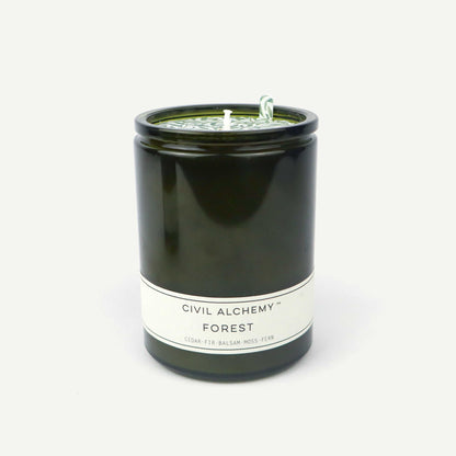 Green candle in a glass jar labeled 'Forest' by Civil Alchemy on a white background