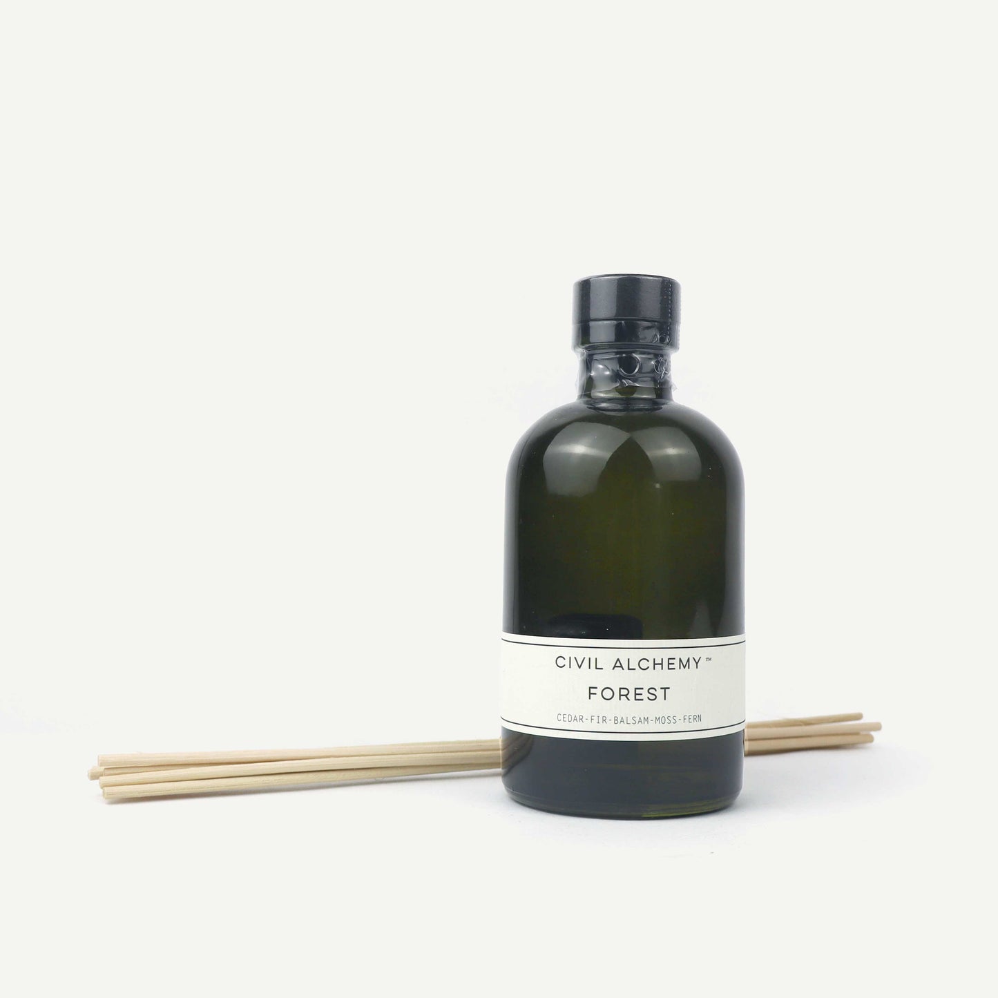 Green bottle with label and wooden sticks on a white background