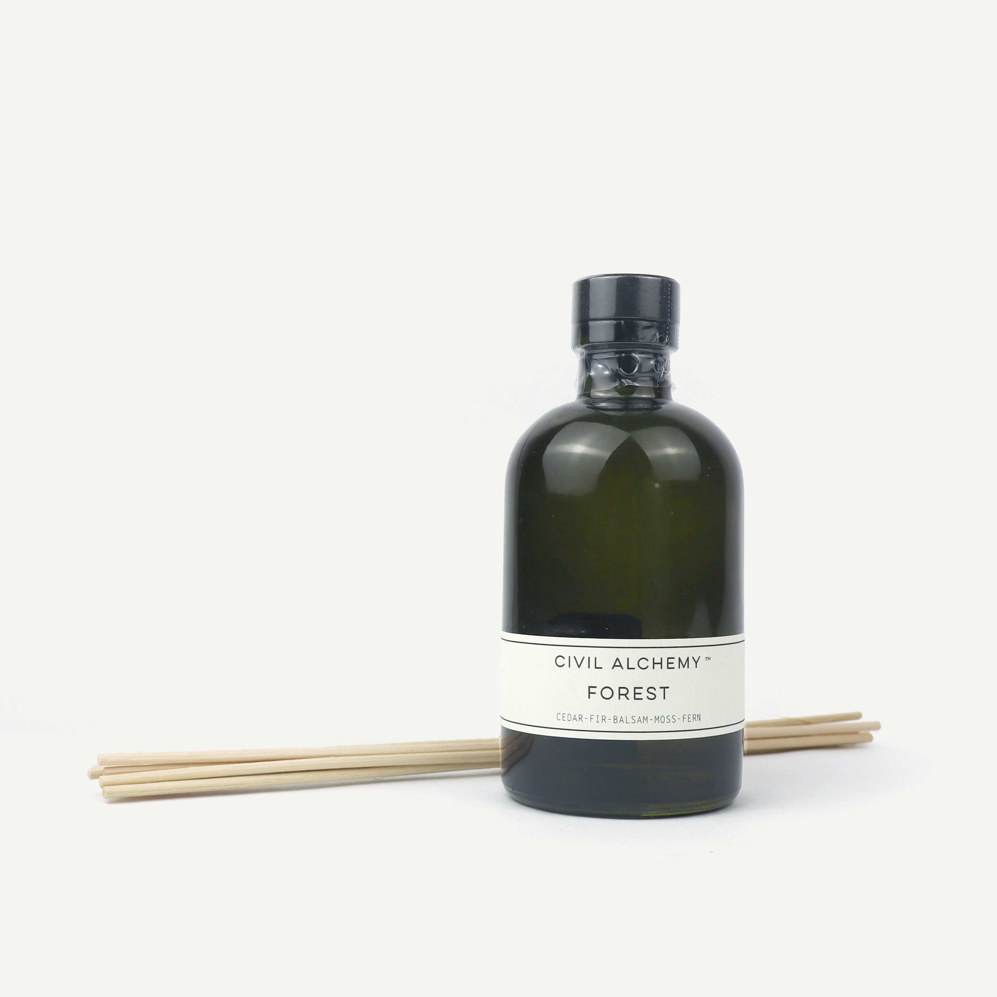 Green bottle with label and wooden sticks on a white background
