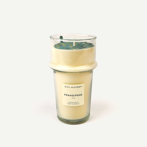 Candle with visible 'Frangipane' label on a white background