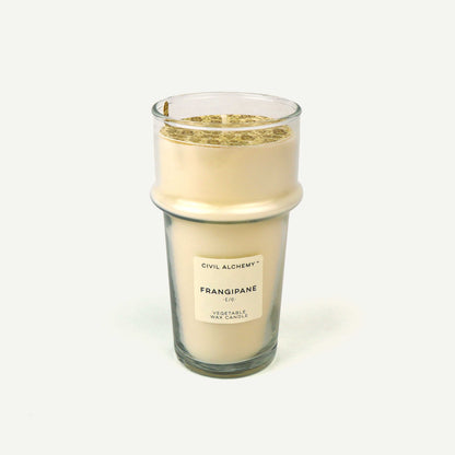 Candle labeled 'Frangipane' by Civil Alchemy on a white background