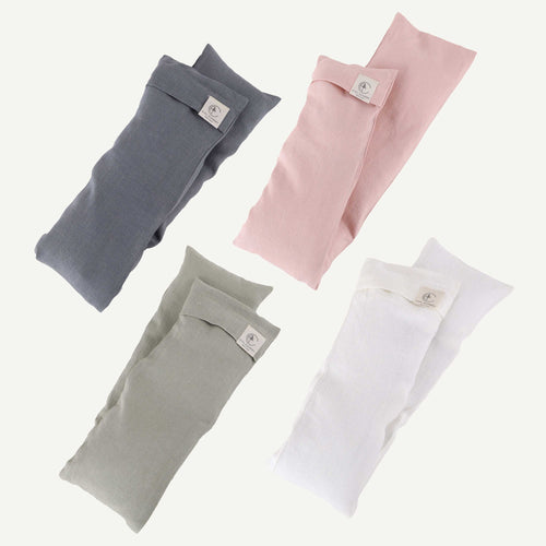 Four folded fabric pouches in gray, pink, green, and white on a white background