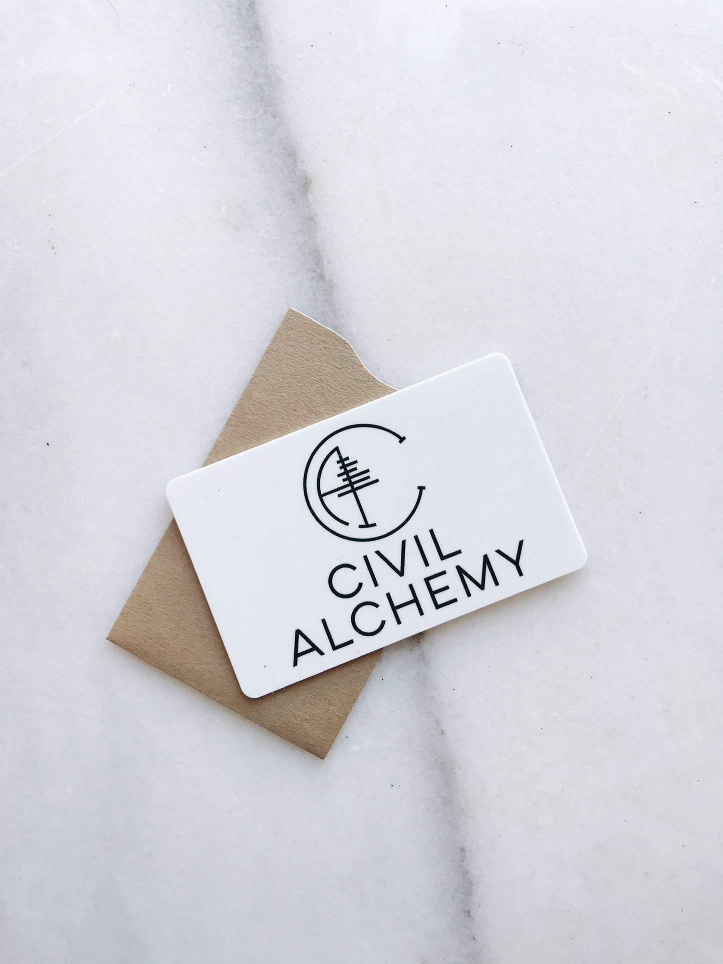 Card with 'Civil Alchemy' logo on a marble surface