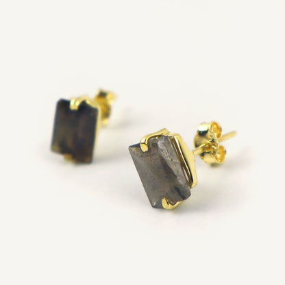 Gold earrings with rectangular stone on a white background