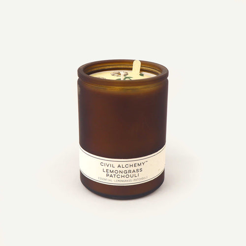 Candle in an amber jar with a label on a white background