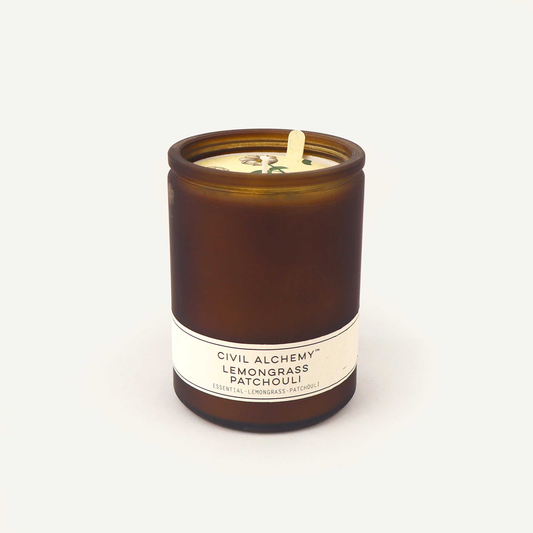 Candle in an amber jar with a label on a white background