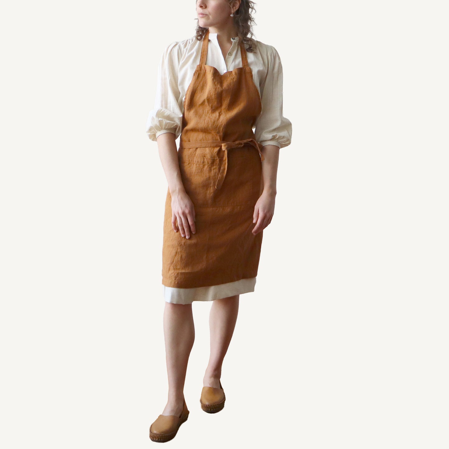 Person wearing a hazelnut apron on a white background