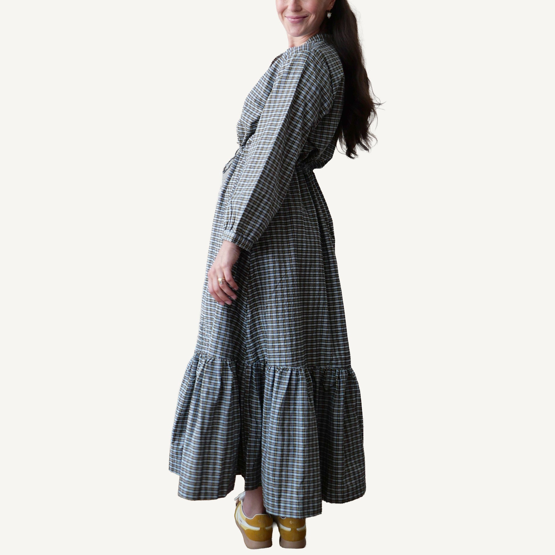 Woman wearing a plaid dress with a plain background