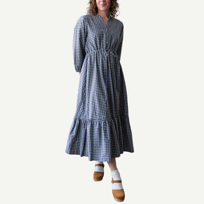 Woman wearing a blue and white checkered dress on a plain background