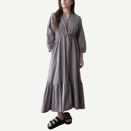 Woman wearing a black and white checkered dress on a plain background