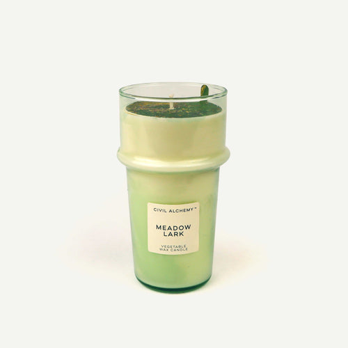 Green candle with a label on a white background
