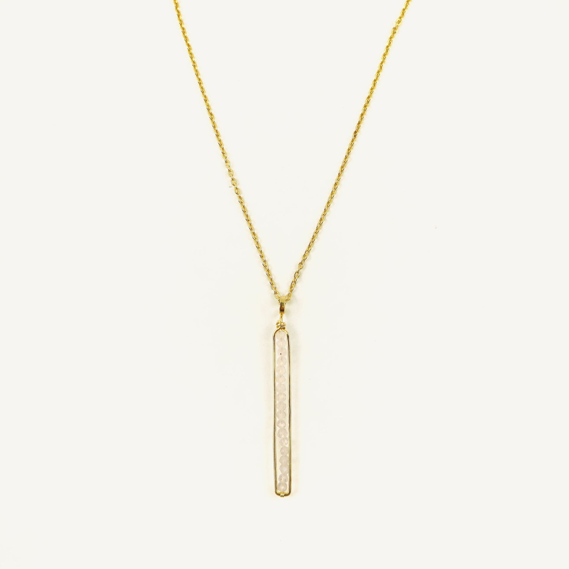 Gold necklace with a vertical bar pendant on a white background