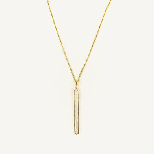 Gold necklace with a vertical bar pendant on a white background