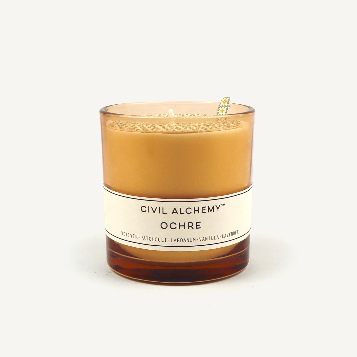 Candle with 'Civil Alchemy Ochre' label on a white background