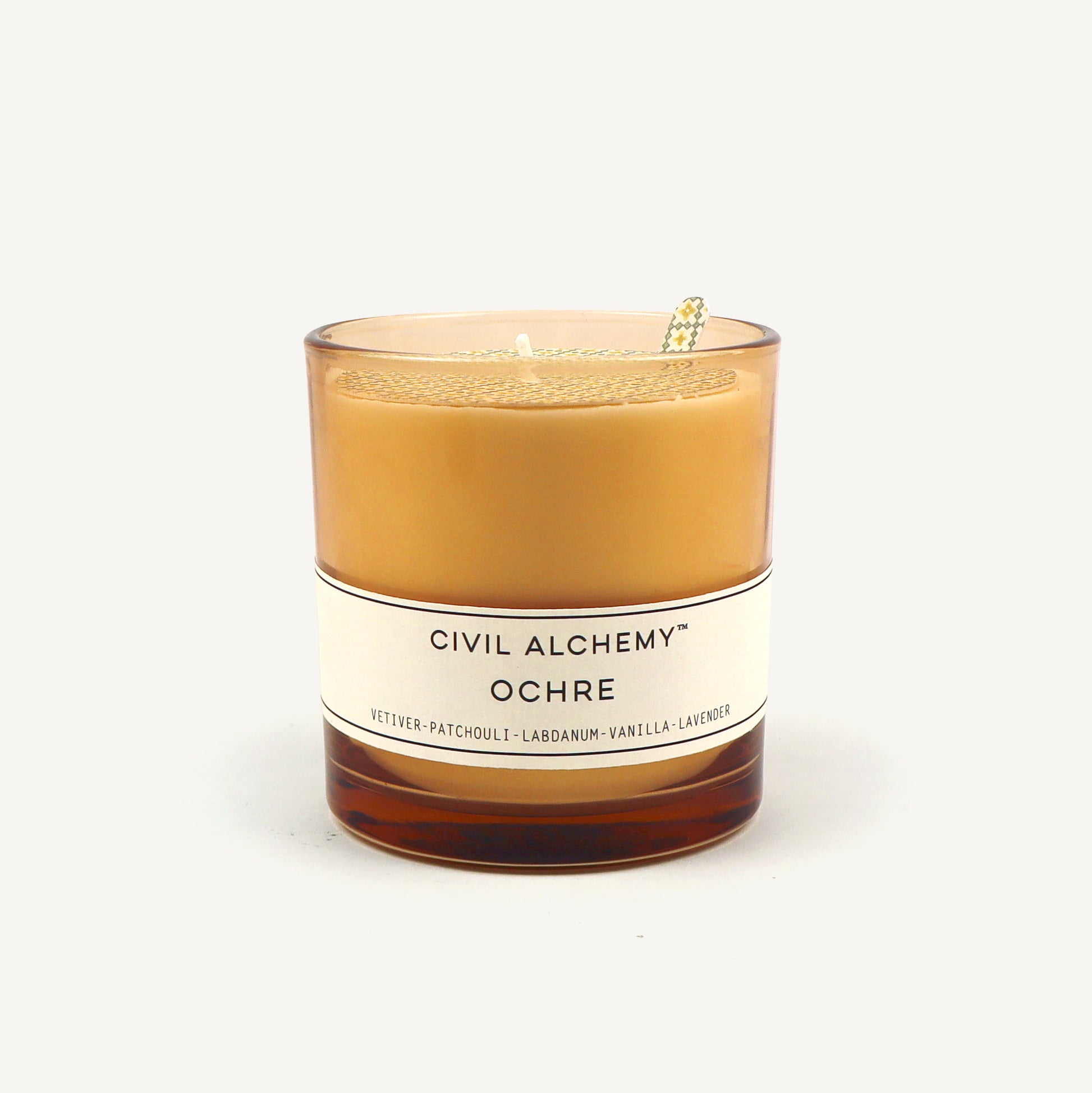 Candle with 'Civil Alchemy Ochre' label on a white background