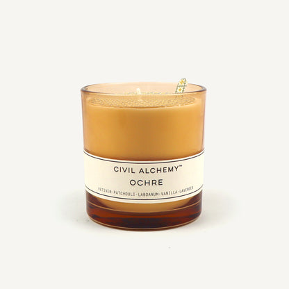 Candle with 'Civil Alchemy Ochre' label on a white background