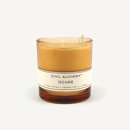 Candle with 'Civil Alchemy Ochre' label on a white background