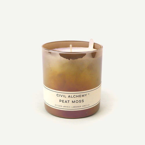 Candle with 'Civil Alchemy Peat Moss' label on a white background