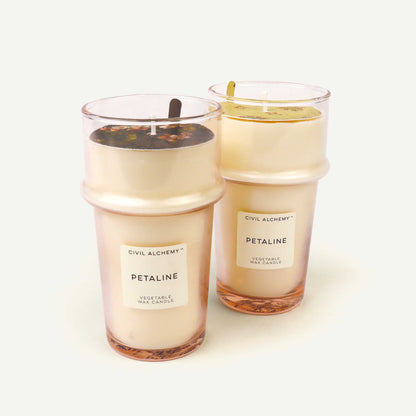 Two candles labeled 'Petaline' by Civil Alchemy on a white background