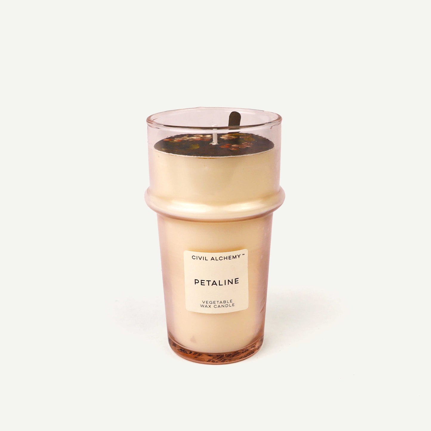 Candle in a pink glass container on a white background
