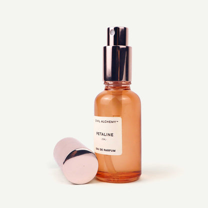 Perfume bottle with rose gold cap and visible brand name on a white background