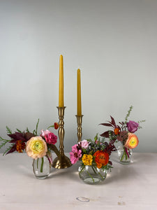 Decorative floral arrangement with a gold candlestick holder on a white background