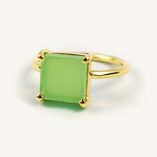 Gold ring with a green square stone on a white background