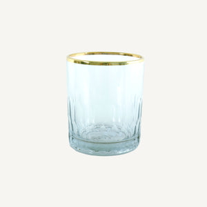 A clear high ball glass with a gold rim.