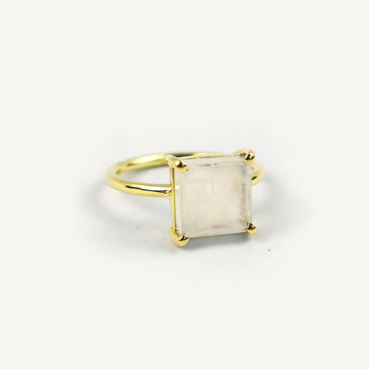 Gold ring with a square-cut stone on a white background