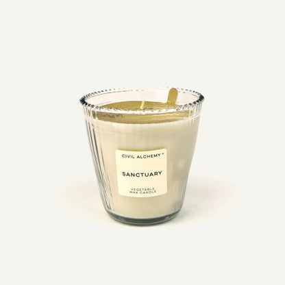 Glass candle labeled 'Sanctuary' by Civil Alchemy on a white background