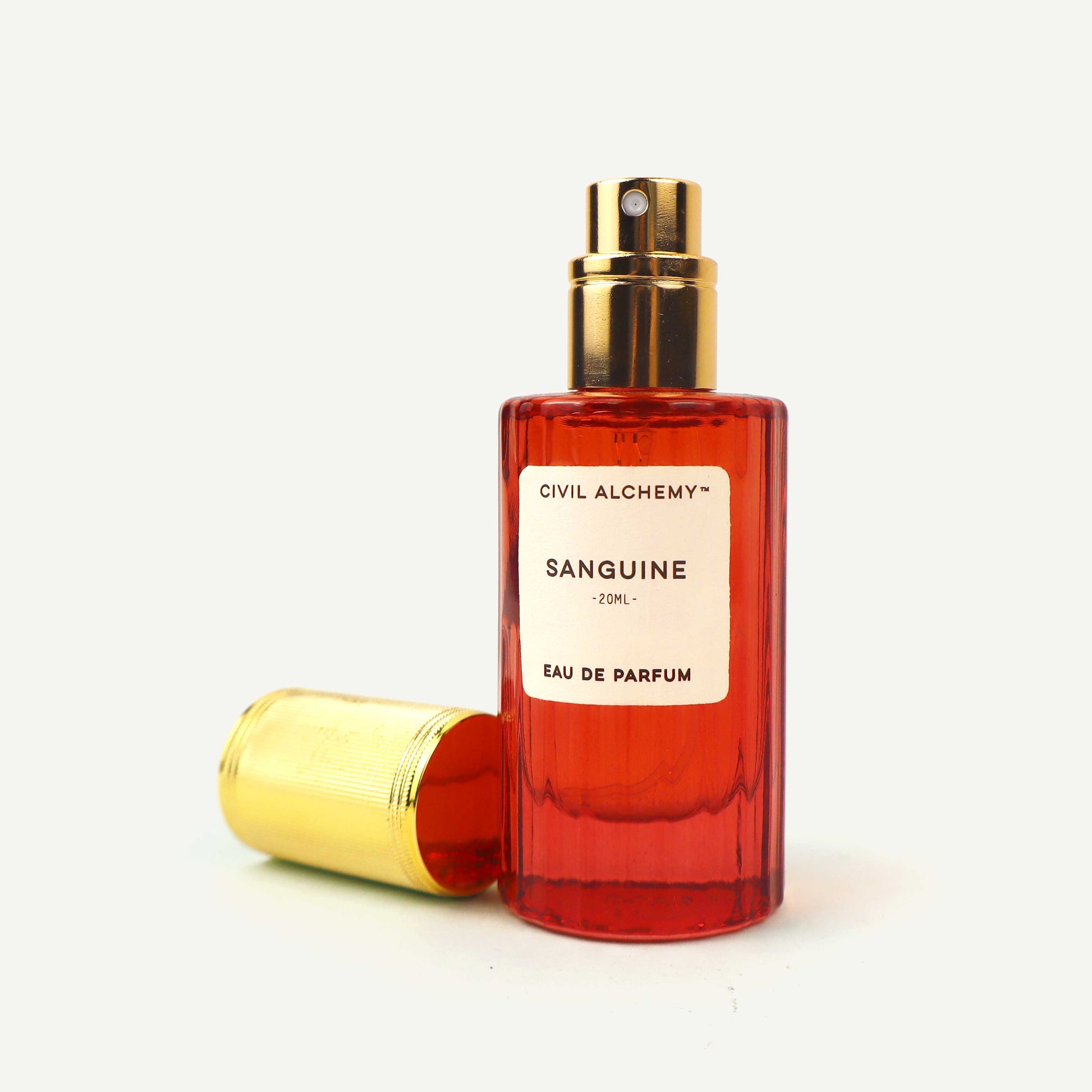 Red perfume bottle with gold cap on a white background