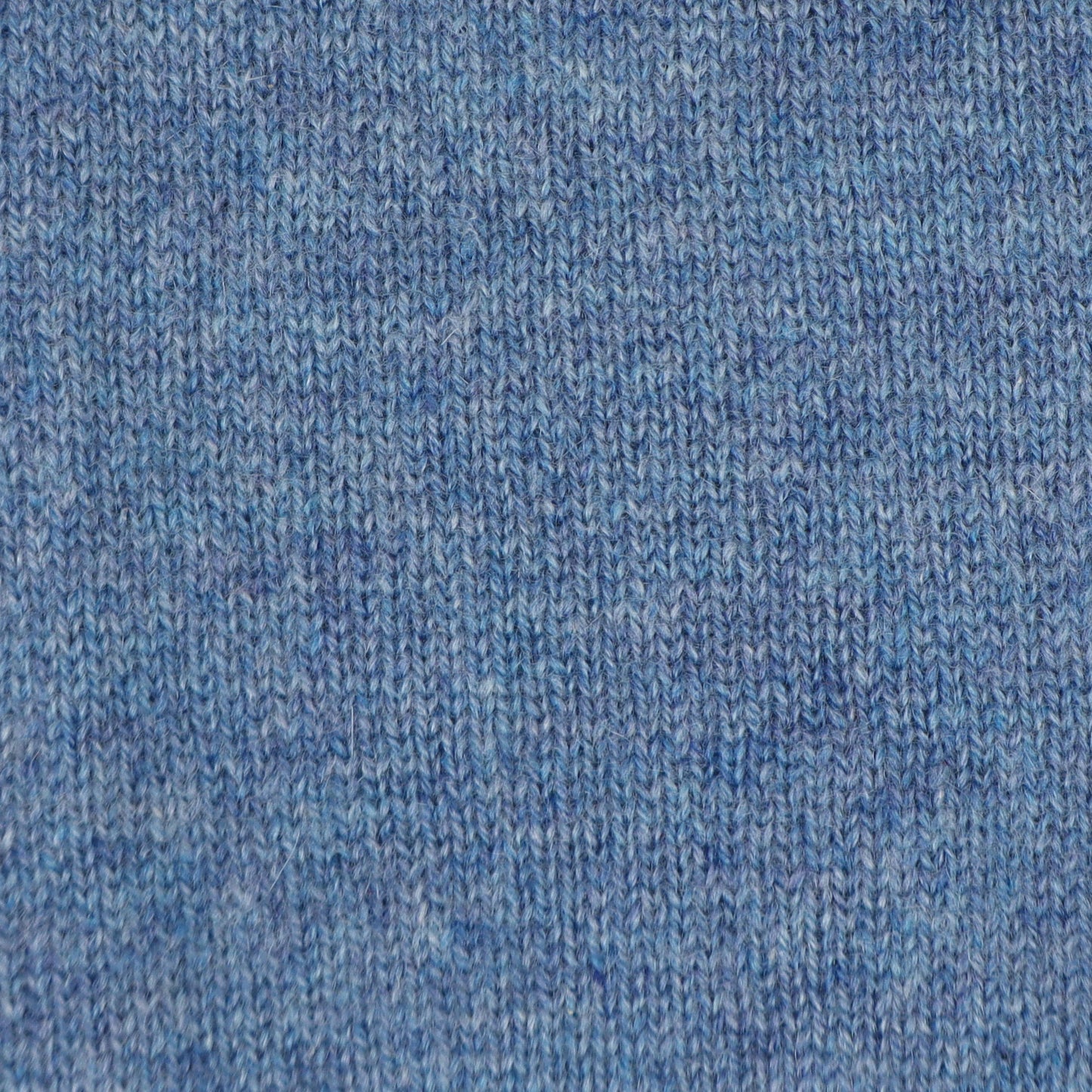 A close-up of a blue knit fabric texture, showing the detailed ribbed pattern and heathered weave.
