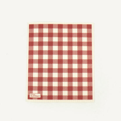 Red and white checkered towel with 'Civil Alchemy' branding on a light beige background