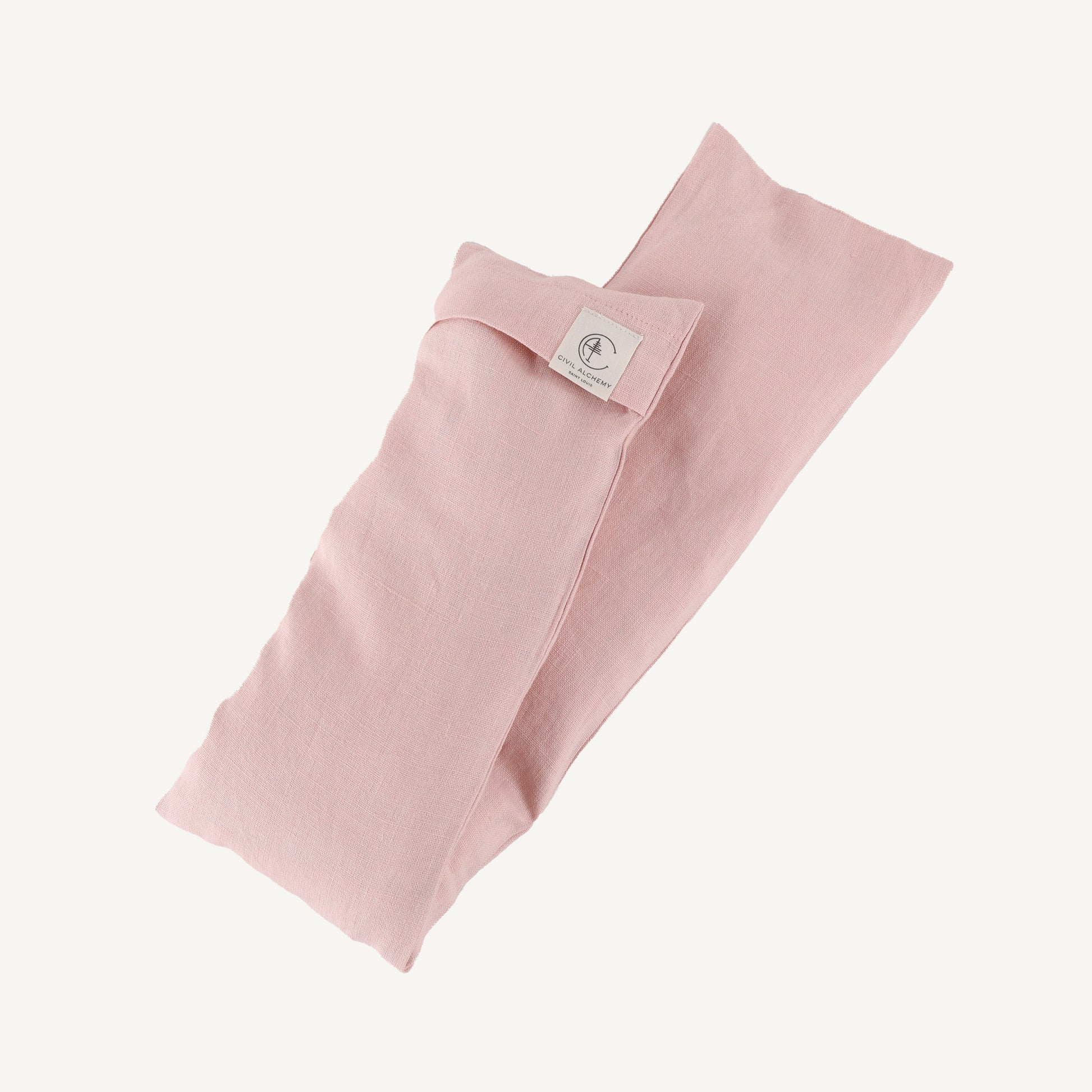 Pink folded fabric with a brand label on a white background