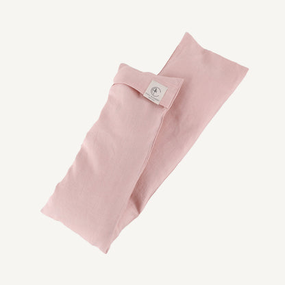 Pink folded fabric with a brand label on a white background