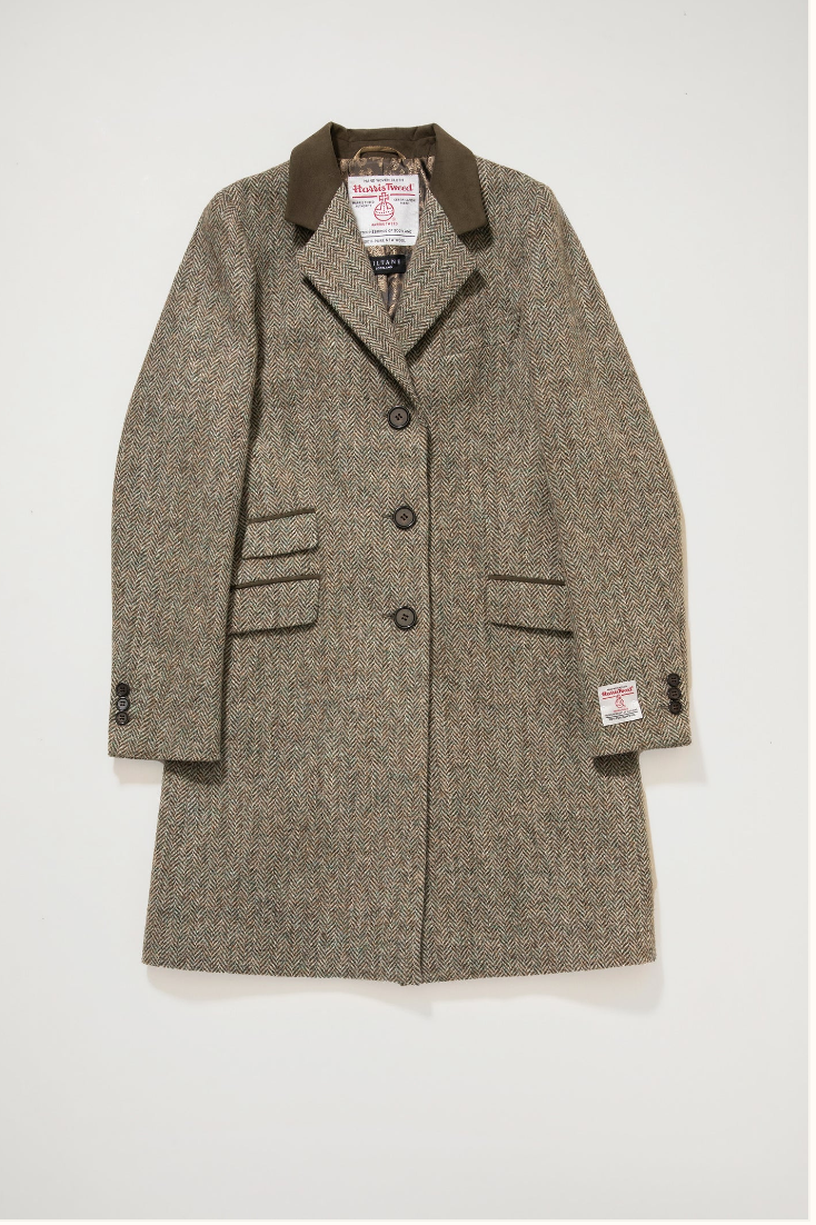 Herringbone patterned coat with brand labels on a white background