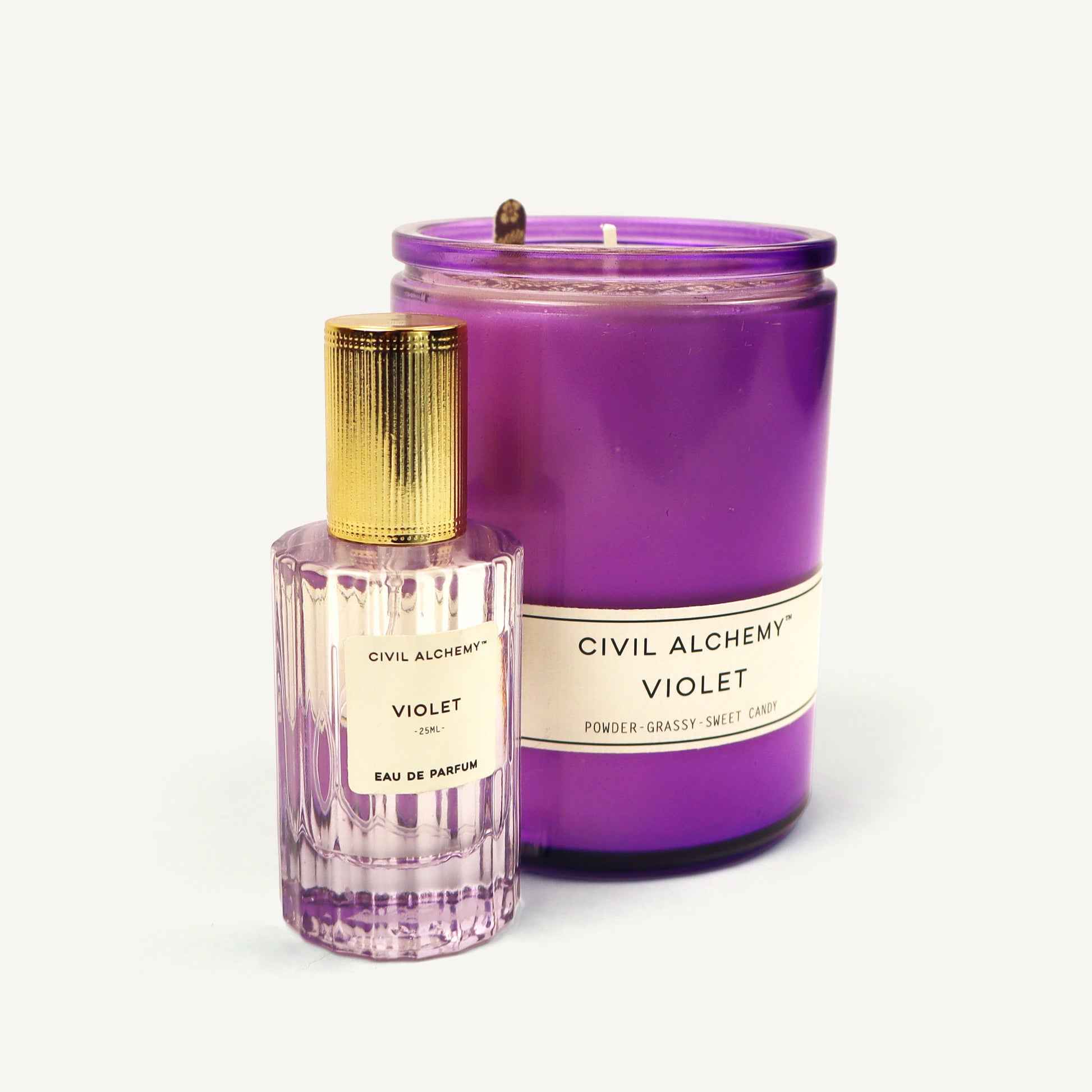 Purple candle and eau de parfum bottle labeled 'Civil Alchemy Violet' on a white background