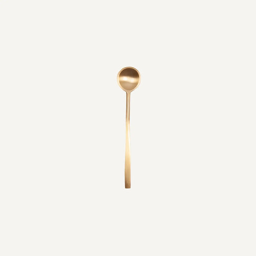 Gold spoon on a light beige background