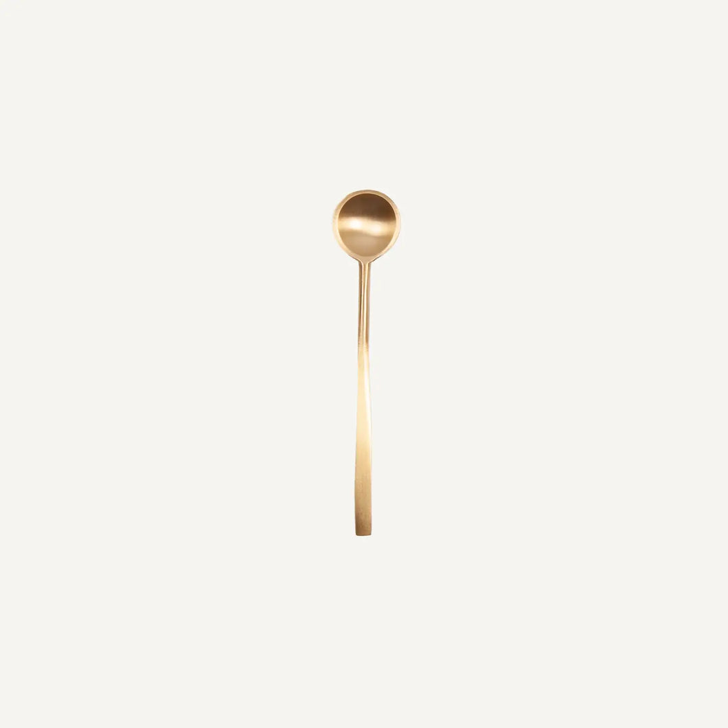 Gold spoon on a light beige background