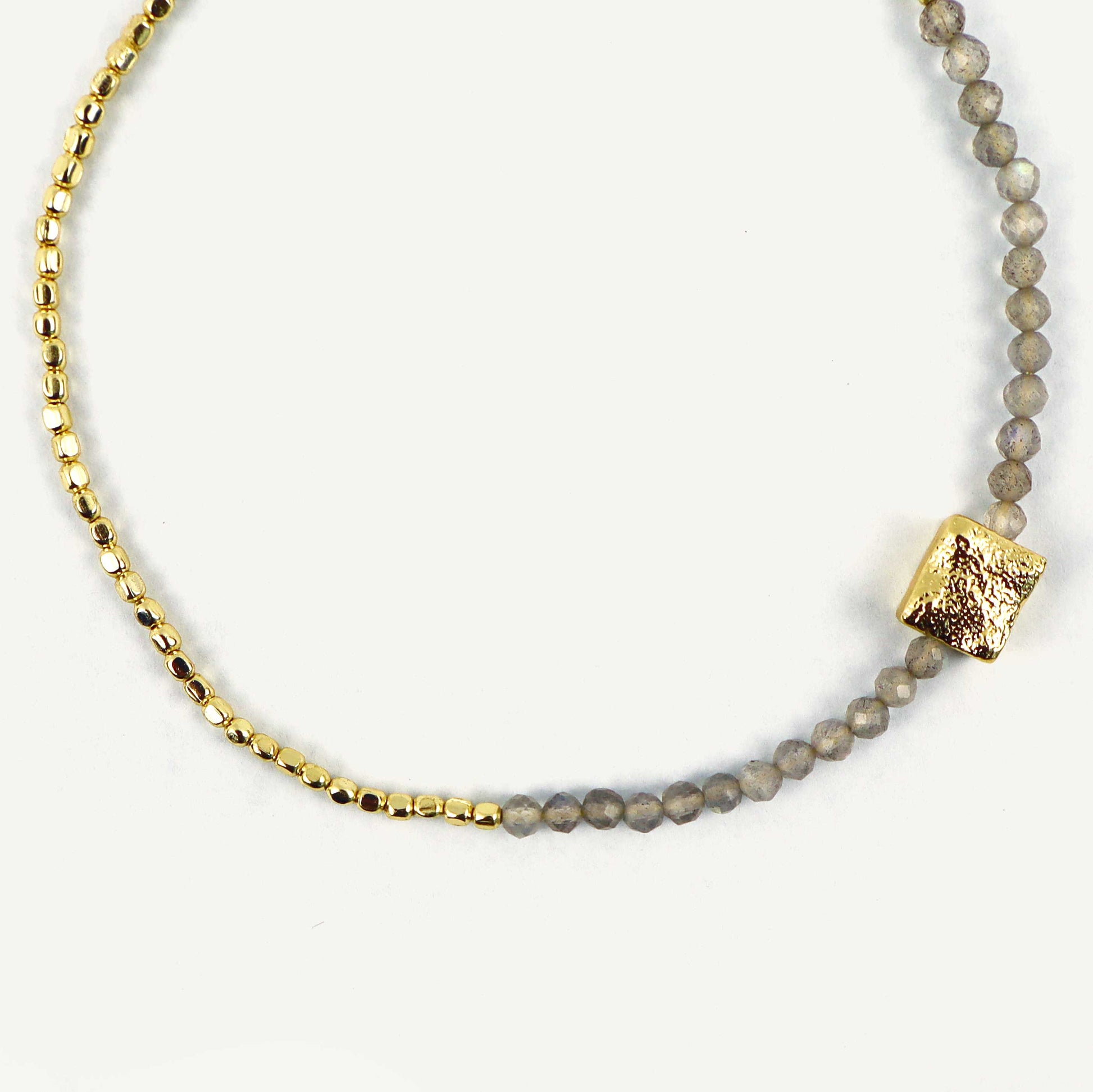 Bracelet with gold and gray beads on a white background