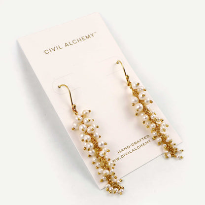 Gold and pearl earrings on a Civil Alchemy branded card