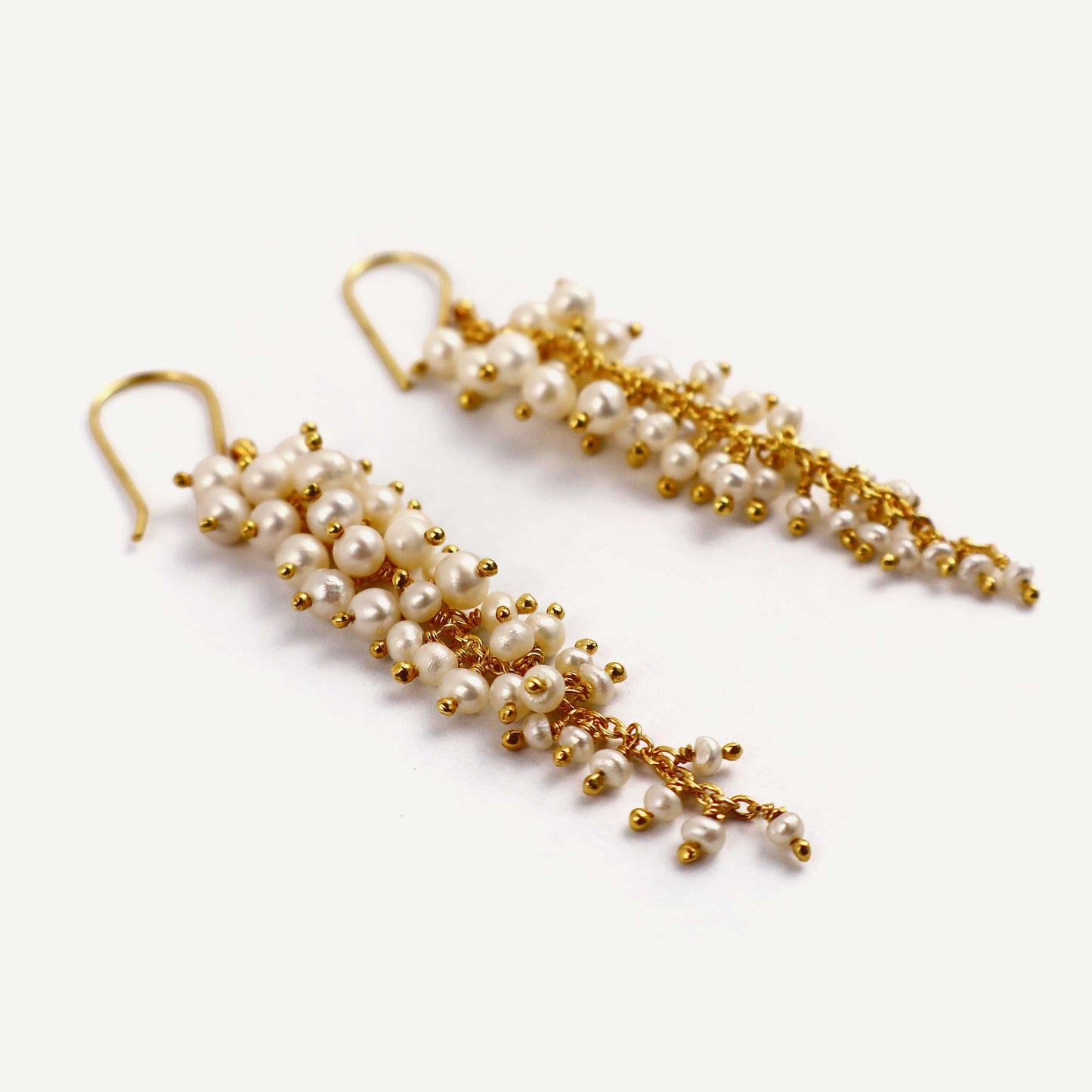 Pair of pearl and gold earrings on a white background